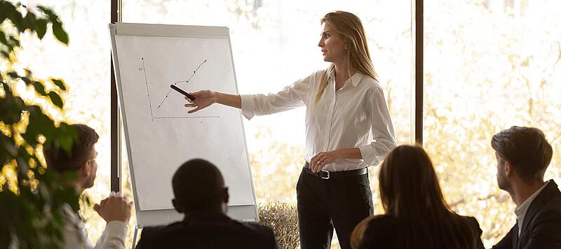 Businessfrau zeigt die Kurve der Conversion Rate Steigerung an einem Board