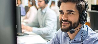 Kundenzentrierung im Callcenter: freundlicher Berater mit Headset - Customer Centricity