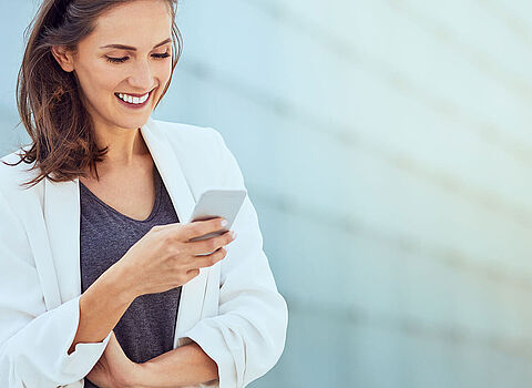 Google Mobile First Index - Businessfrau mit Handy in der Hand