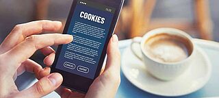 Handy in der Hand: Display zeigt Cookies akzeptieren